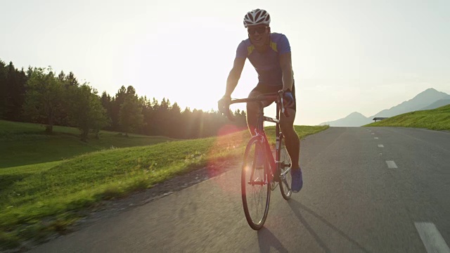 太阳耀斑:金色的阳光照亮了骑着公路自行车的运动员。视频素材
