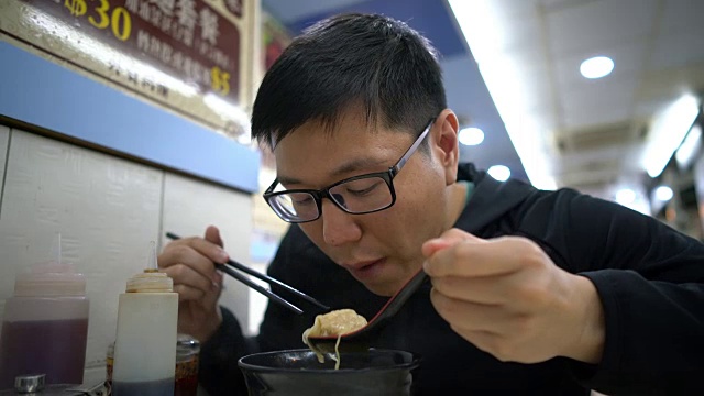 亚洲男子在吃香港馄饨虾面汤视频素材