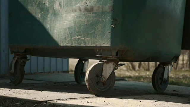 垃圾收集。拾荒者将垃圾收集容器推到垃圾车上视频素材