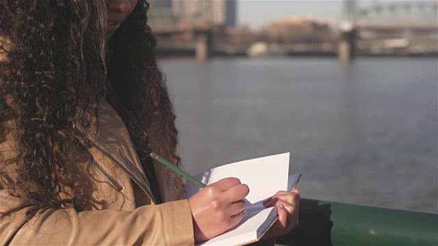 近距离拍摄的年轻女子思考写什么在她的日记视频下载