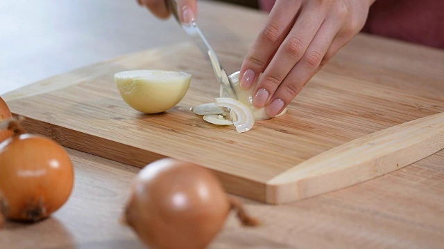 厨师把洋葱切成片。刀，切菜板，洋葱。视频素材