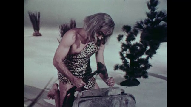1967年，一名装扮成穴居人的男子在凿石头，画外音讨论书写的发明视频下载