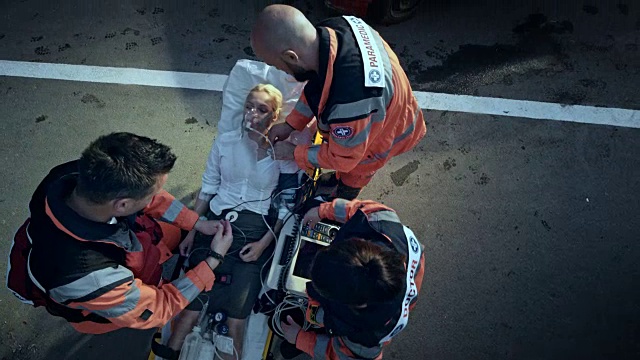 在事故现场，急救人员在担架上稳定受伤的妇女视频素材