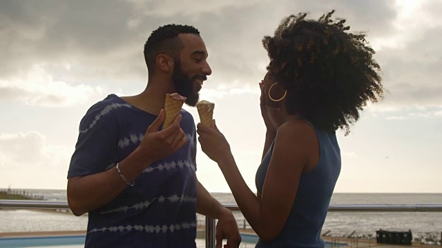 一对情侣在4k海滩吃冰淇淋视频素材