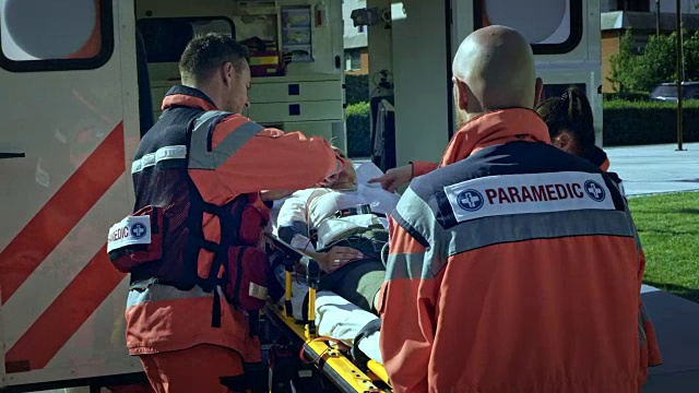 医护人员准备用担架把受伤的妇女抬上救护车视频下载
