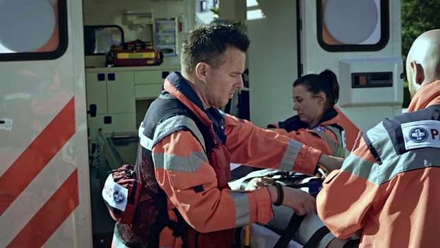 紧急医疗服务队将一名手持氧气面罩的受伤女子抬上救护车视频下载