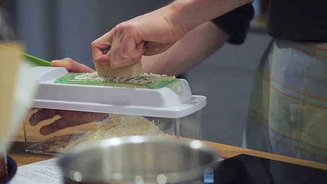 慢动作烹饪:将帕尔马干酪磨碎放入容器中视频素材