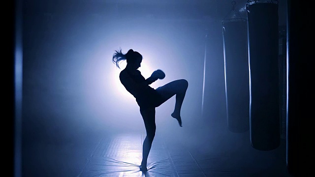 女运动员拳击在冒烟的演播室。黑暗背景上的剪影视频下载