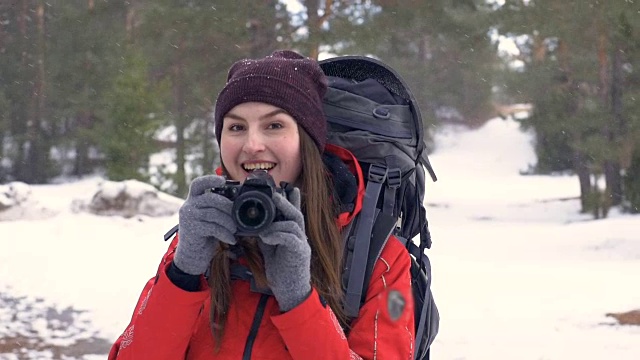 快乐的游客用相机在森林里拍摄雪景。视频下载