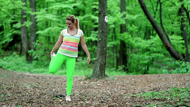 运动女性在自然运动训练前的全身热身和伸展。视频素材