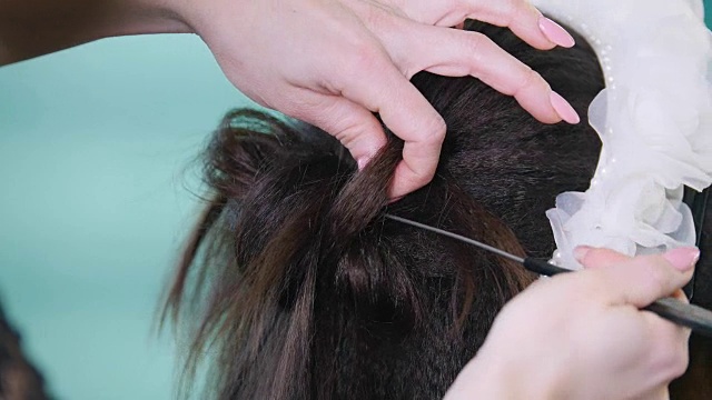 化妆师，发型师，在美容院与客户合作，用卷发器塑造卷发视频下载