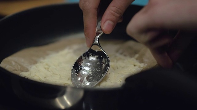 慢动作烹饪:在煎锅中磨碎的奶酪视频素材