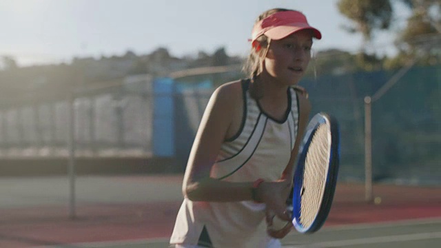 年轻的网球运动员在打网球，身后是太阳耀斑视频素材