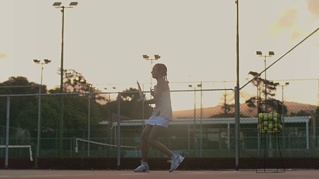 刻苦的网球运动员在下午晚些时候练习发球视频素材