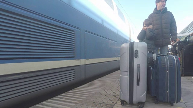 火车上的乘客带着行李箱在车站，父亲和他的儿子视频下载