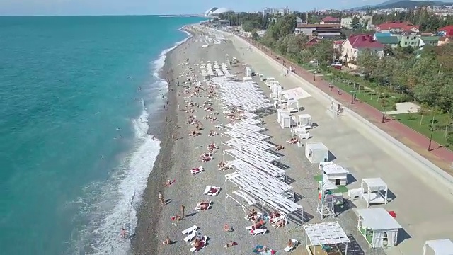 无人机俯瞰海滩日光浴床和雨伞视频下载