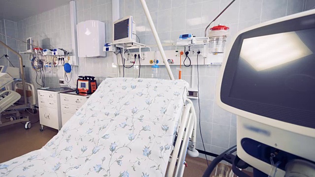 一个设备齐全的医院病房的侧视图，聚焦在一张床和一个显示器上视频素材