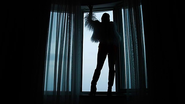 一个女人的剪影站在窗台上靠近一扇开着的窗户视频下载