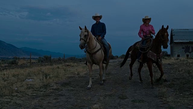 两个年轻的朋友在美国犹他州晚上骑马的实时视频视频素材