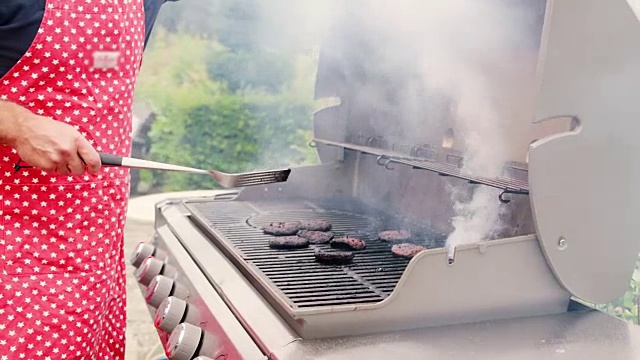 成熟的男人在户外烧烤时烧汉堡视频素材