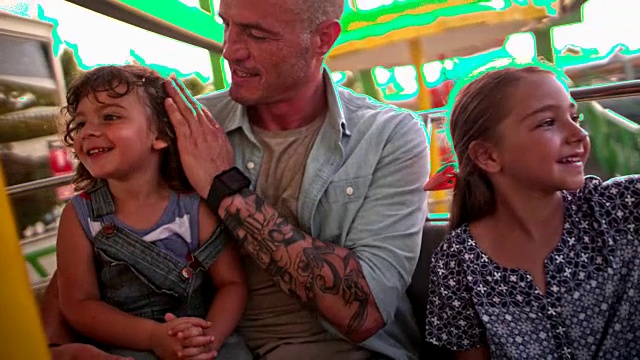年幼的儿子和女儿和父亲一起坐摩天轮视频素材