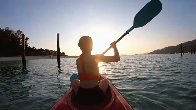 亚洲女子游泳在日落的皮划艇在利普，萨顿，泰国视频素材