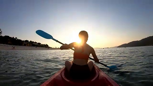亚洲女子游泳在日落的皮划艇在利普，萨顿，泰国视频素材