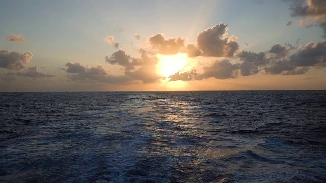 伴着夕阳在海上尾随一艘远洋游轮视频素材