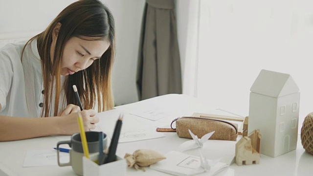 一位亚洲妇女正在画画，准备自己动手做家装用纸视频下载