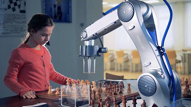 聪明的小女孩和机械手臂在学校下棋。视频素材