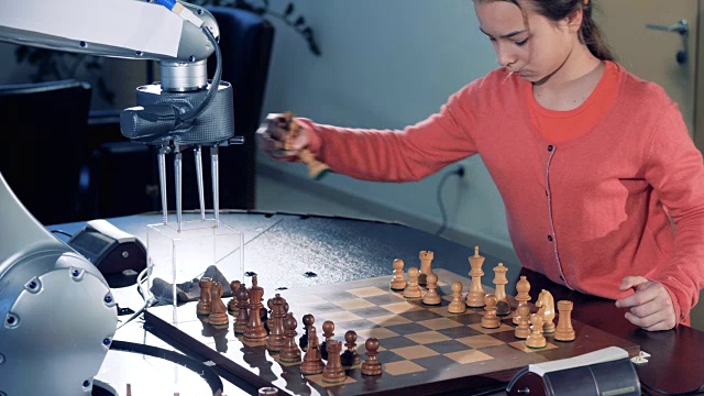 小女孩在准备棋盘，准备和机器人下棋。视频素材