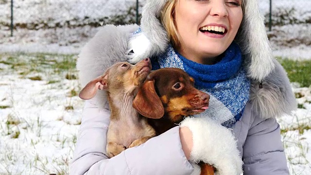 冬天，一个女人和她的小狗在外面玩耍视频素材