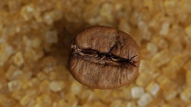 棕色的咖啡豆在甜甜的红糖结晶上，微距拍摄视频下载
