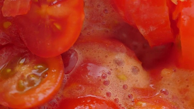在搅拌机里放入番茄片。缓慢的运动。特写镜头。视频素材