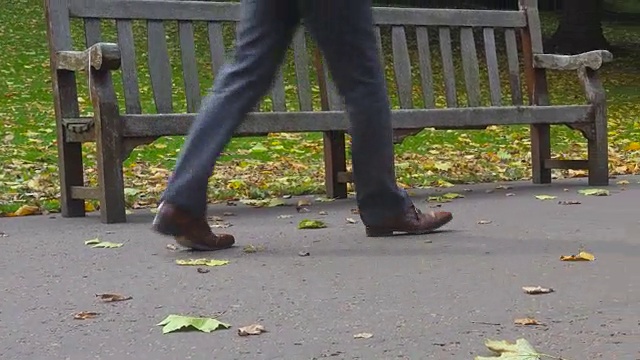 一位匿名的商人走在秋天公园的小路上视频素材