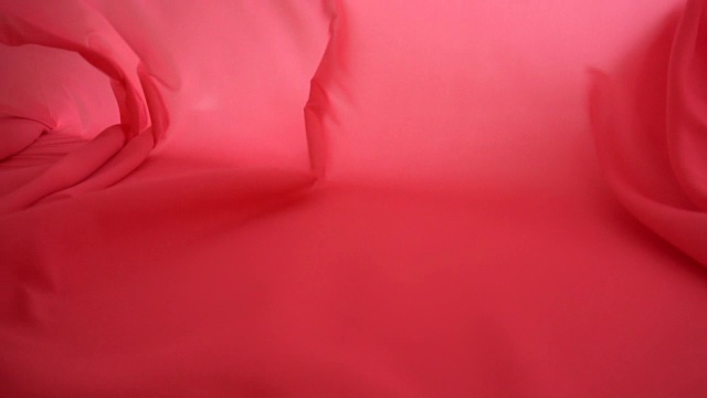 一个背景纹理柔软的红色织物纺织材料反向移动。视频素材