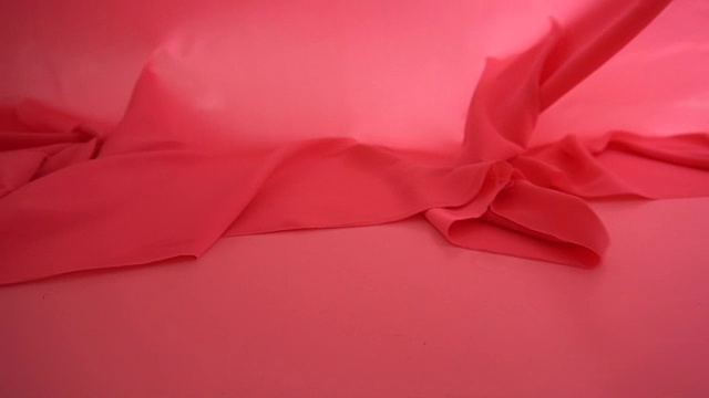 一个背景纹理柔软的红色织物纺织材料反向移动。视频素材