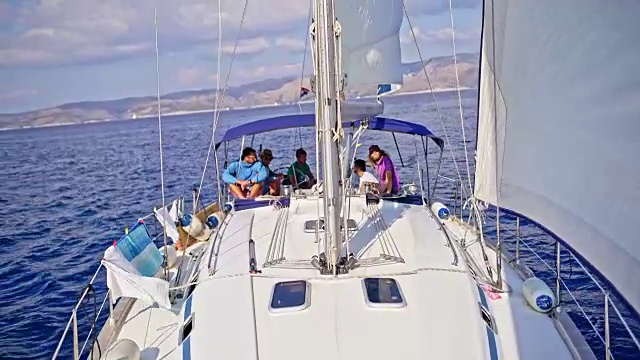 4K朋友在阳光明媚的帆船上航行，实时视频素材