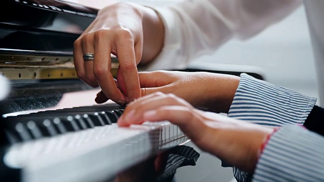 音乐课上学生与老师弹钢琴的特写视频购买