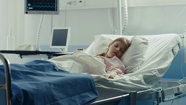 可爱的生病小女孩睡在儿童医院的一张床上。现代儿科病房，高质量的医疗保健。视频素材