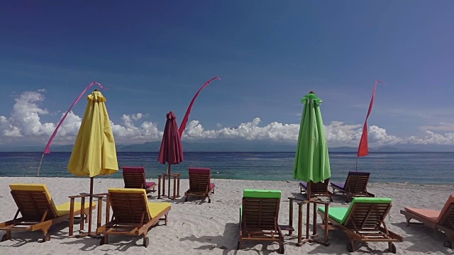 沙滩上的空日光浴床和雨伞。慢动作视频素材