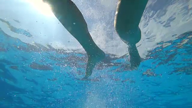 快乐的女性与开放的眼睛游泳在水下在夏季的慢动作泡沫的背景视频素材