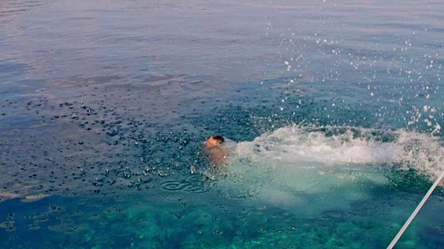 4K人跳入阳光明媚的夏日海洋，慢镜头视频素材