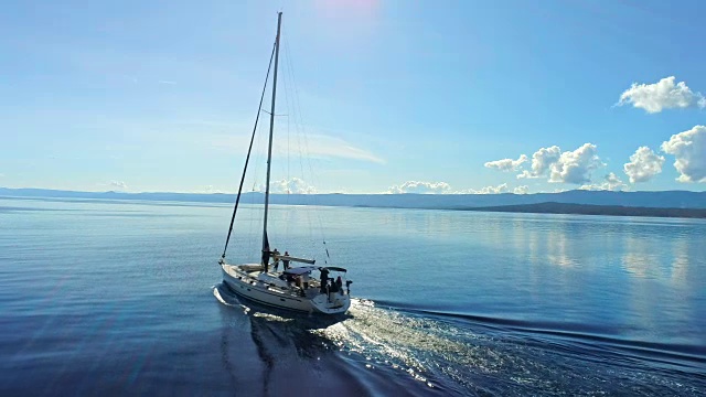 4K无人机实时拍摄宁静晴朗的蓝色海洋上的帆船视频素材