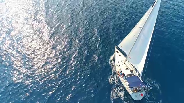 4K无人机实时拍摄宁静、阳光明媚的蓝色海洋上的帆船视频素材
