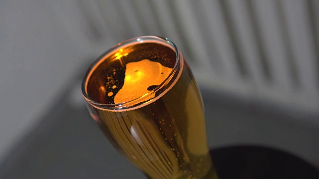 冷光啤酒在一个玻璃孤立的黑色背景。精酿啤酒近距离。旋转360度。视频素材
