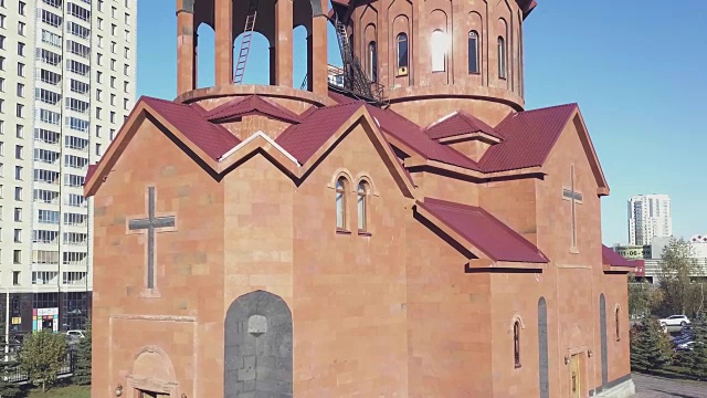 以城市为背景的红砖砌成的基督教庙宇。城市里的俄罗斯东正教教堂，红砖映衬着蓝色的天空视频下载