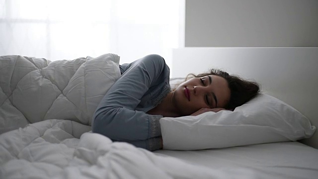 一个女人在床上醒来视频素材