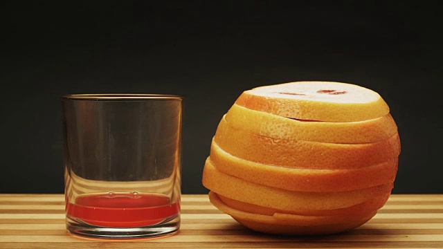 新鲜的橙子葡萄柚被挤进玻璃杯里。定格动画视频素材