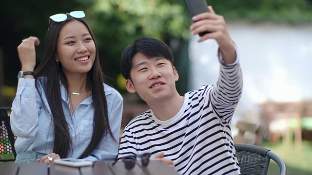 亚洲青少年在户外咖啡馆自拍视频素材